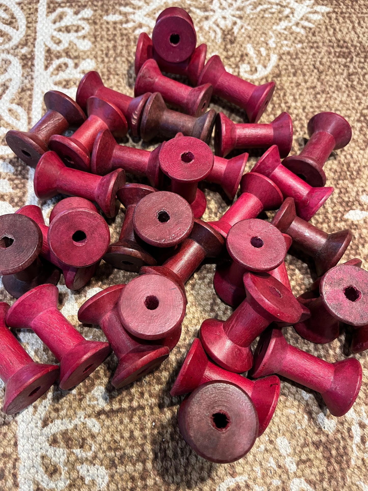 Tiny pink wooden bobbins