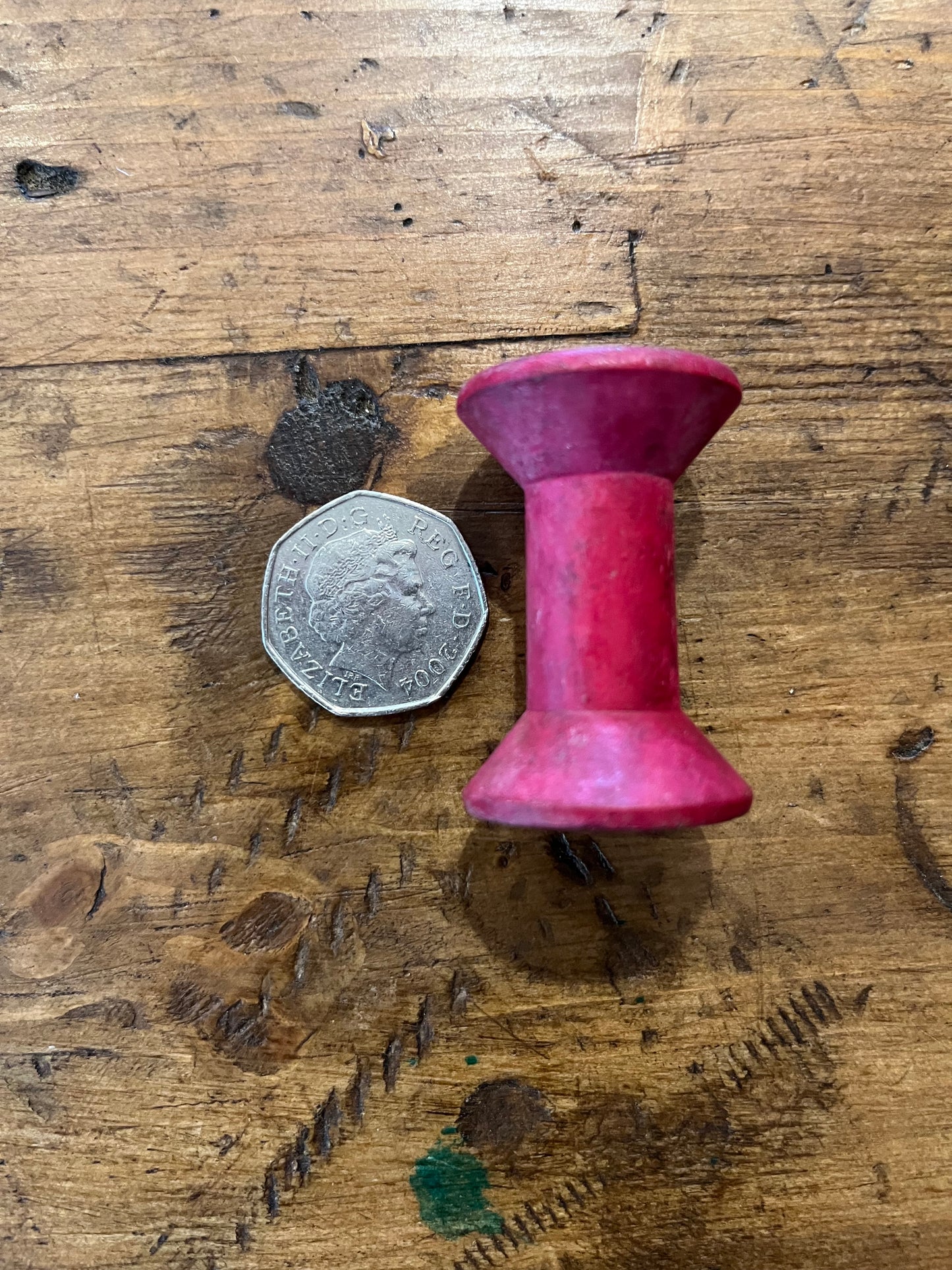 Tiny pink wooden bobbins