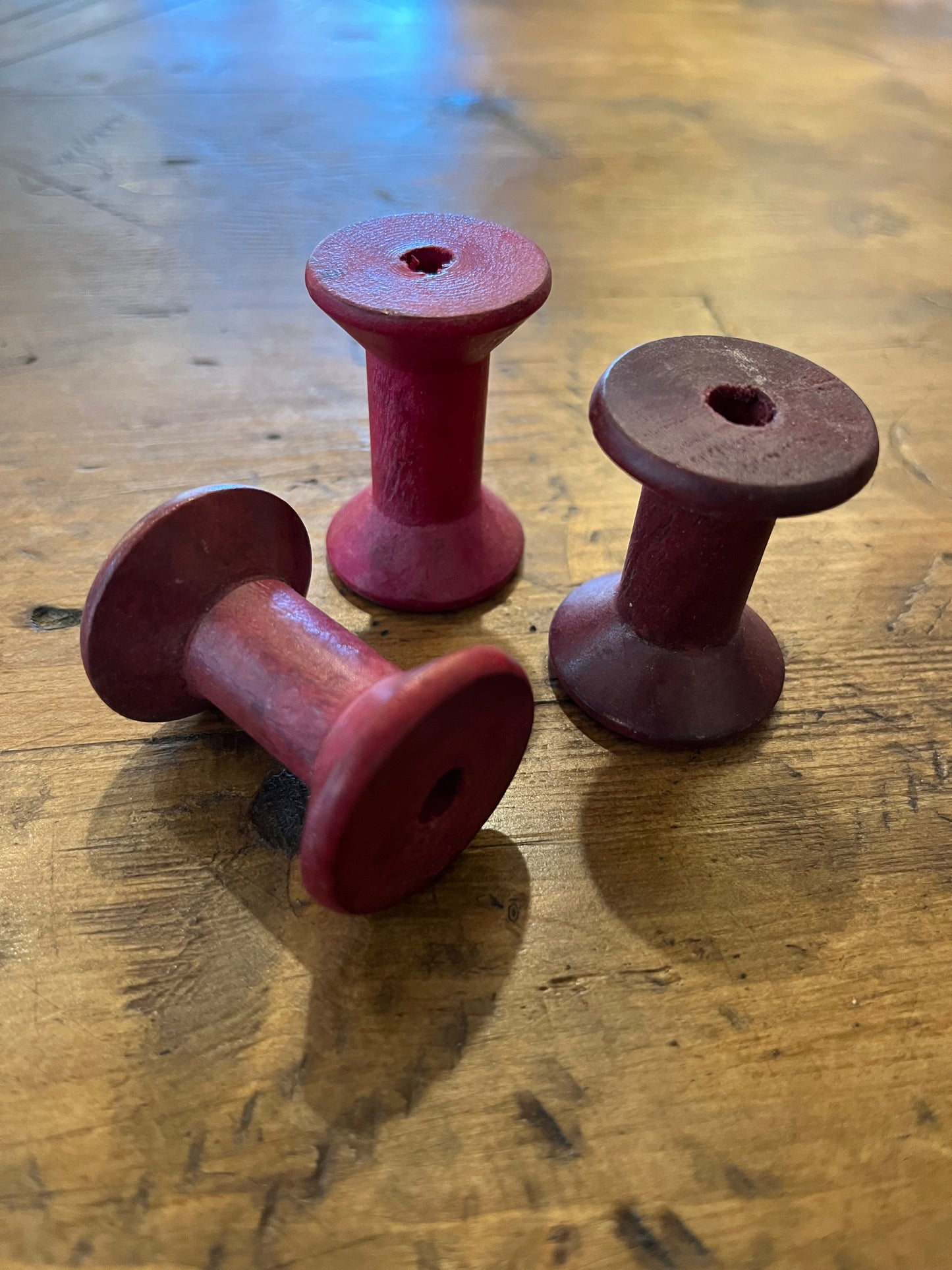 Tiny pink wooden bobbins